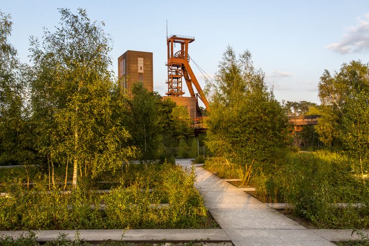 Die Halden, Schienenwege und Freiflächen zwischen den Schachtanlagen sind heute der ZOLLVEREIN® Park, der Bestandteil des Emscher Landschaftsparks (ELP) ist. 

Auf der Grundlage des Masterplans „Industrielandschaft Zollverein“, den 2003 die Agentur Agence Ter unter Leitung von Prof. Henri Bava erstellt hat, wandelte ein interdisziplinäres Team aus Landschaftsarchitekten, Künstlern und Designern die ehemalige Industriebrache um. 

Neben dem Orientierungs-, Beleuchtungs- und Wegekonzept  bieten  Bänke, Pavillons, Spielorte und Aussichtsplattformen den Besuchern Aufenthalts- und Erholungsqualität. Der ursprüngliche Charakter des ehemals industriell genutzten Geländes bleibt erhalten: Überall wachsen typische postindustrielle Pflanzen wie Birken, Robinien und Sommerflieder. 

Die 1851 in Betrieb genommene Gründerschachtanlage 1/2/8 ist die älteste Schachtanlage der Zeche Zollverein. Die vorhandenen Ziegelmassivbauten stammen aus dem ersten Jahrzehnt des 20. Jahrhunderts, sämtliche Erweiterungsbauten nach 1932 wurden im architektonischen Stil der Schachtanlage Zollverein XII errichtet. Auf Schacht 1/2/8 befanden sich mit der Markenkontrolle, Kaue und Lampenstube auch die Sozialräume für die auf Schacht 1/2/8 und Schacht XII tätigen Bergleute. Nach der Stilllegung 1986 wurde die Schachtanlage 1/2/8 saniert und beherbergt heute Ateliers sowie die renommierte Kulturinstitution PACT Zollverein. 2000 wurde die Schachtanlage 1/2/8 in die Denkmalliste der Stadt Essen aufgenommen und gehört seit 2001 zum UNESCO-Welterbe. 

Areal B [Schacht 1/2/8]