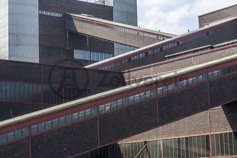 Die Geschichte Zollvereins beginnt in den Pioniertagen des heutigen Ruhrgebiets. Der erste Schacht wurde 1847 abgeteuft, vier Jahre später die erste Kohle gefördert: Vier weitere Anlagen entstanden, die letzte war die Schachtanlage Zollverein XII,  die ab 1932 die Förderung der gesamten Zollverein-Kohle zentral übernahm. 

Die Gebäude der 1928 bis 1932 im Stil der „Neuen Sachlichkeit“ nach Entwürfen der Architekten Fritz Schupp und Martin Kremmer gebauten Anlage sind nach dem Prinzip „Form follows function“ zum optimalen Ablauf der Kohleförderung und -aufbereitung angeordnet. Trotz Rekordzahlen wie 12.000 Tagestonnen verwertbarer Steinkohle machte das Ende der Schwerindustrie auch vor Zollverein nicht Halt. Am 23. Dezember 1986 fuhr die letzte Schicht ein. An diesem Tag stand die Zeche bereits unter Denkmalschutz, 1990 begannen die Sanierungsarbeiten und seit 2001 sind Zeche und Kokerei Zollverein UNESCO-Welterbe. Mit dem Denkmalpfad Zollverein, dem Ruhr Museum und dem Red Dot Design Museum sind auf Schacht XII drei der beliebtesten Touristenziele der Region angesiedelt. Das Doppelbock-Fördergerüst der Schachtanlage ist heute ein Wahrzeichen für das gesamte Ruhrgebiet. 

Die Bandbrücken sind Teil des Gebäudeensembles der Kokerei Zollverein. Sie bilden die funktionale Verknüpfung zwischen den einzelnen Gebäuden und Anlageteilen auf der sogenannten „schwarzen“ Seite und verdeutlichen, welchen Weg die Kohle bzw. der Koks von der Zeche bis zur Verladung durchlaufen hat.

Der Wagenumlauf befindet sich zwischen der Wipperhalle und der Rückseite des Doppelbock-Fördergerüstes von Schacht XII. In dem langgestreckten Gebäude wurden die Förderwagen, nachdem sie entleert wurden, wieder zurück zum Schacht geführt. Heute ist der Wagenumlauf Teil des Denkmalpfads Zollverein.