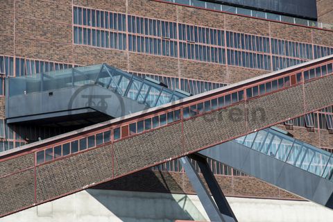 Das größte Übertagegebäude auf Zollverein, die Kohlenwäsche [A14], war zu Betriebszeiten eine Riesenmaschine, die täglich 23.000 Tonnen Rohkohle sortierte und klassierte. Von 2003 bis 2006 wurde sie von dem Office for Metropolitan Architecture (OMA) unter Leitung von Rem Koolhaas und dem Essener Büro Böll & Krabel umfassend saniert. Die Kohlenwäsche ist zentrale Anlaufstelle für Besucher sowie Museumsgebäude des 2010 eröffneten Ruhr Museums und des Portals der Industriekultur. Die oberen Etagen gehören mit den authentisch erhaltenen Übertageanlagen zum Denkmalpfad ZOLLVEREIN®. Auf dem Dach der Kohlenwäsche sind zwei Aussichtsplattformen installiert, die einen Rundblick auf das Gelände und die Region bieten. 

Die beiden 58 Meter langen Rolltreppen an der Kohlenwäsche [A14] befördern die Besucher direkt auf die 24-Meter-Ebene der Kohlenwäsche und von dort wieder nach unten. Die beiden Sonderanfertigungen von ThyssenKrupp Elevator – eine für die Auffahrt, eine für die Abfahrt – orientieren sich an den historischen Bandbrücken. Das Konzept wurde von dem Rotterdamer Office for Metropolitan Architecture (OMA) entwickelt. Eine Fahrt auf einer der beiden höchsten freistehenden Fahrtreppen Deutschlands dauert 90 Sekunden. Highlight: Bei Dunkelheit leuchten die Fahrtreppen orangerot.

Die diagonal und waagerecht zwischen den Gebäuden verlaufenden Bandbrücken sind fester Bestandteil der Gebäudeensembles von Zeche und Kokerei Zollverein. In ihrem Inneren befinden sich Bänder, auf denen die Rohkohle bzw. Kokskohle oder Koks zu den einzelnen Verarbeitungsstufen transportiert wurden. Sie illustrieren sozusagen den Weg der Kohle, neben dem Transportband verlaufen  schmale Wege und Treppe für die Bergleute. Im Gegensatz zu den reinen Mannschaftsbrücken sind die Bandbrücken aus Stahlskelettbauweise mit parallel verlaufenden Fensterbändern geschlossen. 

Ort: Areal A [Schacht XII], Kohlenwäsche [A14]