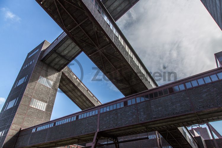 Die diagonal und waagerecht zwischen den Gebäuden verlaufenden Bandbrücken sind fester Bestandteil der Gebäudeensembles von Zeche und Kokerei Zollverein. In ihrem Inneren befinden sich Bänder, auf denen die Rohkohle bzw. Kokskohle oder Koks zu den einzelnen Verarbeitungsstufen transportiert wurden. Sie illustrieren sozusagen den Weg der Kohle, neben dem Transportband verlaufen  schmale Wege und Treppe für die Bergleute. Im Gegensatz zu den reinen Mannschaftsbrücken sind die Bandbrücken aus Stahlskelettbauweise mit parallel verlaufenden Fensterbändern geschlossen. 

Ort: Areal A [Schacht XII], Kohlenwäsche [A14]