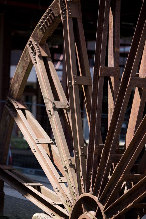 Das Doppelbockfördergerüst von Zollverein Schacht XII ist durch seine vier, jeweils zu zweit übereinander angeordneten Seilscheiben gekennzeichnet. Jedes der Seile zog zwei Förderkörbe: ein Korb bewegte sich nach oben, während der zweite auf dem Weg nach unter Tage war. Die Seilscheiben drehten das aus dem Schacht kommende Seil über die Treibscheiben der Fördermaschinen, die für den Antrieb der Körbe sorgten. 

Die zu sehende Seilscheibe ist eine in zwei Hälften geteilte Seilscheibe und steht unterhalb des ehemaligen Wagenumlaufs auf dem Gleisboulevard, dem ehemaligen Verladebahnhof der Zeche Zollverein Schacht XII.