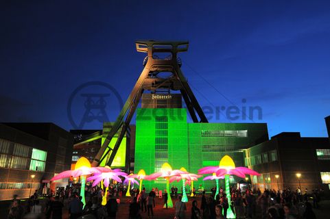 Seit der ersten ExtraSchicht im Jahr 2001 richtet die „Nacht der Industriekultur“ alljährlich ihr Rampenlicht auf die aktuellen und ehemaligen Stätten industrieller Arbeit im Ruhrgebiet. Das UNESCO-Welterbe Zollverein ist seit der ersten Stunde ein wichtiger Spielort für das Veranstaltungshighlight. Die Besucher auf Zollverein erwartet zwischen 18 Uhr und 2 Uhr nachts ein bunter Veranstaltungsmix mit vielen interaktiven Kulturangeboten, Ausstellungen, Musikbeiträgen, Licht- und Kunstinstallationen, Walk Acts und internationalen Straßentheaterinszenierungen. 

Das 55 Meter hohe Doppelbock-Fördergerüst ist das Wahrzeichen der Zeche Zollverein, der Stadt Essen und der gesamten Region: Die als Doppelstrebengerüst in Vollwandbauweise konstruierte Förderanlage ermöglichte eine doppelte Fördermechanik. Dadurch konnte die doppelte Menge an Förderwagen bzw. Fördergefäßen transportiert werden. Zollverein Schacht XII galt zu Betriebszeiten als die leistungsstärkste Zeche der Welt. 250 Stufen führen auf die oberste Plattform des Gerüstes, deren Seilscheiben sich auch heute noch manchmal drehen: Der Schacht wird von der RAG AG für die zentrale Wasserhaltung genutzt.

Areal A [Schacht XII], Fördergerüst [A1]