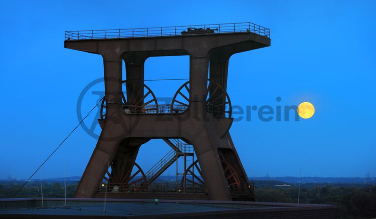 Das 55 Meter hohe Doppelbock-Fördergerüst ist das Wahrzeichen der Zeche Zollverein, der Stadt Essen und der gesamten Region: Die als Doppelstrebengerüst in Vollwandbauweise konstruierte Förderanlage ermöglichte eine doppelte Fördermechanik. Dadurch konnte die doppelte Menge an Förderwagen bzw. Fördergefäßen transportiert werden. Zollverein Schacht XII galt zu Betriebszeiten als die leistungsstärkste Zeche der Welt. 250 Stufen führen auf die oberste Plattform des Gerüstes, deren Seilscheiben sich auch heute noch manchmal drehen: Der Schacht wird von der RAG AG für die zentrale Wasserhaltung genutzt.