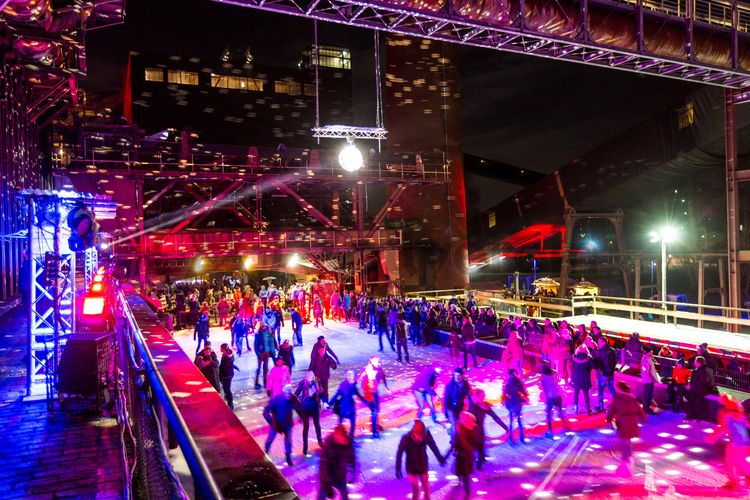 In der Wintersaison tummeln sich an mindestens zwei Abenden Discofans und Schlittschuhläufer auf bei der Eisdisco auf der ZOLLVEREIN® Eisbahn, dem “wahrscheinlich faszinierendsten Ort zum Schlittschuhlaufen bundesweit”. Entlang der Koksöfen, in denen einst Kohle bei 1.000 Grad Celsius zu Koks gebacken wurde, erstreckt sich im Winter über eine Länge von 150 Meter die ZOLLVEREIN® Eisbahn. Insbesondere am Abend, wenn die 1.800 Quadratmeter große Eisfläche mit der Installation „Monochromatic Red and Blue“ (1999) von Jonathan Speirs und Mark Major zu einem beeindruckenden Lichtkunstwerk.in atmosphärisches Licht getaucht wird, verspricht das Schlittschuhlaufen vor der beeindruckenden Kulisse der Kokerei Zollverein ein einzigartiges Erlebnis.

Areal C [Kokerei], Druckmaschinengleis [C74]