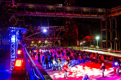 In der Wintersaison tummeln sich an mindestens zwei Abenden Discofans und Schlittschuhläufer auf bei der Eisdisco auf der ZOLLVEREIN® Eisbahn, dem “wahrscheinlich faszinierendsten Ort zum Schlittschuhlaufen bundesweit”. Entlang der Koksöfen, in denen einst Kohle bei 1.000 Grad Celsius zu Koks gebacken wurde, erstreckt sich im Winter über eine Länge von 150 Meter die ZOLLVEREIN® Eisbahn. Insbesondere am Abend, wenn die 1.800 Quadratmeter große Eisfläche mit der Installation „Monochromatic Red and Blue“ (1999) von Jonathan Speirs und Mark Major zu einem beeindruckenden Lichtkunstwerk.in atmosphärisches Licht getaucht wird, verspricht das Schlittschuhlaufen vor der beeindruckenden Kulisse der Kokerei Zollverein ein einzigartiges Erlebnis.

Areal C [Kokerei], Druckmaschinengleis [C74]