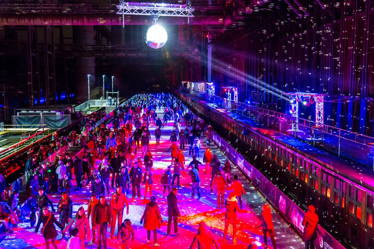 In der Wintersaison tummeln sich an mindestens zwei Abenden Discofans und Schlittschuhläufer auf bei der Eisdisco auf der ZOLLVEREIN® Eisbahn, dem “wahrscheinlich faszinierendsten Ort zum Schlittschuhlaufen bundesweit”. Entlang der Koksöfen, in denen einst Kohle bei 1.000 Grad Celsius zu Koks gebacken wurde, erstreckt sich im Winter über eine Länge von 150 Meter die ZOLLVEREIN® Eisbahn. Insbesondere am Abend, wenn die 1.800 Quadratmeter große Eisfläche mit der Installation „Monochromatic Red and Blue“ (1999) von Jonathan Speirs und Mark Major zu einem beeindruckenden Lichtkunstwerk.in atmosphärisches Licht getaucht wird, verspricht das Schlittschuhlaufen vor der beeindruckenden Kulisse der Kokerei Zollverein ein einzigartiges Erlebnis.

Areal C [Kokerei], Druckmaschinengleis [C74]