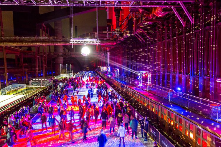 In der Wintersaison tummeln sich an mindestens zwei Abenden Discofans und Schlittschuhläufer auf bei der Eisdisco auf der ZOLLVEREIN® Eisbahn, dem “wahrscheinlich faszinierendsten Ort zum Schlittschuhlaufen bundesweit”. Entlang der Koksöfen, in denen einst Kohle bei 1.000 Grad Celsius zu Koks gebacken wurde, erstreckt sich im Winter über eine Länge von 150 Meter die ZOLLVEREIN® Eisbahn. Insbesondere am Abend, wenn die 1.800 Quadratmeter große Eisfläche mit der Installation „Monochromatic Red and Blue“ (1999) von Jonathan Speirs und Mark Major zu einem beeindruckenden Lichtkunstwerk.in atmosphärisches Licht getaucht wird, verspricht das Schlittschuhlaufen vor der beeindruckenden Kulisse der Kokerei Zollverein ein einzigartiges Erlebnis.

Areal C [Kokerei], Druckmaschinengleis [C74]