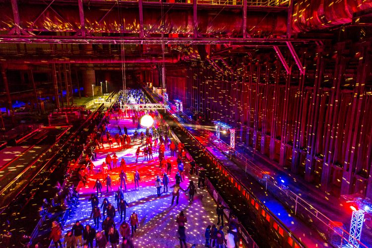 In der Wintersaison tummeln sich an mindestens zwei Abenden Discofans und Schlittschuhläufer auf bei der Eisdisco auf der ZOLLVEREIN® Eisbahn, dem “wahrscheinlich faszinierendsten Ort zum Schlittschuhlaufen bundesweit”. Entlang der Koksöfen, in denen einst Kohle bei 1.000 Grad Celsius zu Koks gebacken wurde, erstreckt sich im Winter über eine Länge von 150 Meter die ZOLLVEREIN® Eisbahn. Insbesondere am Abend, wenn die 1.800 Quadratmeter große Eisfläche mit der Installation „Monochromatic Red and Blue“ (1999) von Jonathan Speirs und Mark Major zu einem beeindruckenden Lichtkunstwerk.in atmosphärisches Licht getaucht wird, verspricht das Schlittschuhlaufen vor der beeindruckenden Kulisse der Kokerei Zollverein ein einzigartiges Erlebnis.

Areal C [Kokerei], Druckmaschinengleis [C74]