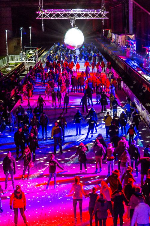 In der Wintersaison tummeln sich an mindestens zwei Abenden Discofans und Schlittschuhläufer auf bei der Eisdisco auf der ZOLLVEREIN® Eisbahn, dem “wahrscheinlich faszinierendsten Ort zum Schlittschuhlaufen bundesweit”. Entlang der Koksöfen, in denen einst Kohle bei 1.000 Grad Celsius zu Koks gebacken wurde, erstreckt sich im Winter über eine Länge von 150 Meter die ZOLLVEREIN® Eisbahn. Insbesondere am Abend, wenn die 1.800 Quadratmeter große Eisfläche mit der Installation „Monochromatic Red and Blue“ (1999) von Jonathan Speirs und Mark Major zu einem beeindruckenden Lichtkunstwerk.in atmosphärisches Licht getaucht wird, verspricht das Schlittschuhlaufen vor der beeindruckenden Kulisse der Kokerei Zollverein ein einzigartiges Erlebnis.

Areal C [Kokerei], Druckmaschinengleis [C74]