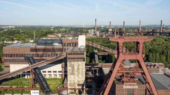 Das 55 Meter hohe Doppelbock-Fördergerüst ist das Wahrzeichen der Zeche Zollverein, der Stadt Essen und der gesamten Region: Die als Doppelstrebengerüst in Vollwandbauweise konstruierte Förderanlage ermöglichte eine doppelte Fördermechanik. Dadurch konnte die doppelte Menge an Förderwagen bzw. Fördergefäßen transportiert werden. Zollverein Schacht XII galt zu Betriebszeiten als die leistungsstärkste Zeche der Welt. 250 Stufen führen auf die oberste Plattform des Gerüstes, deren Seilscheiben sich auch heute noch manchmal drehen: Der Schacht wird von der RAG AG für die zentrale Wasserhaltung genutzt.

Areal A [Schacht XII], Fördergerüst [A1]

Das größte Übertagegebäude auf Zollverein, die Kohlenwäsche [A14], war zu Betriebszeiten eine Riesenmaschine: Täglich wurden dort 23.000 Tonnen Rohkohle sortiert und klassiert. Von 2003 bis 2006 wurde die Kohlenwäsche vom Office for Metropolitan Architecture (OMA) unter Leitung von Rem Koolhaas und dem Essener Büro Böll & Krabel umfassend saniert und für die spätere Nutzung vorbereitet. 

Eine 58 Meter lange Rolltreppe bringt die Besucher heute direkt in das RUHR.VISITORCENTER Essen auf der 24-Meter-Ebene. 2010 eröffnete das Ruhr Museum in der Kohlenwäsche, das in drei Etagen eine Dauerausstellung zu den Kategorien Gegenwart – Gedächtnis – Geschichte präsentiert. Die oberen Etagen gehören mit den authentisch erhaltenen Übertageanlagen zum Denkmalpfad ZOLLVEREIN®. Auf dem Dach der Kohlenwäsche sind zwei Aussichtsplattformen installiert, die einen Rundblick auf das Gelände und die Region bieten. Das Portal der Industriekultur informiert über industriekulturelle Angebote im Ruhrgebiet und in Nordrhein-Westfalen.

Areal A [Schacht XII], Kohlenwäsche [A14]