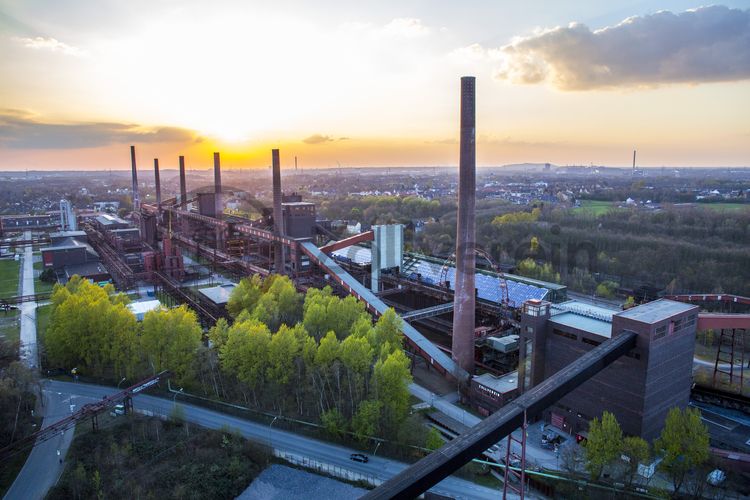 Die Kokerei Zollverein wurde von 1957 bis 1961 nach Plänen des Architekten Fritz Schupp gebaut, nach Erweiterungsarbeiten war sie ab 1973 die größte Zentralkokerei Europas. Täglich waren bis zu 1.000 Koker rund um die Uhr im Einsatz, bis zu 8.600 Tonnen Koks wurden pro Tag produziert. 1993 wurde die Kokerei stillgelegt, im Jahr 2000 in die Denkmalliste der Stadt Essen aufgenommen, seit 2001 gehört sie zum UNESCO-Welterbe. 2010 ist die Kokerei in den Besitz der Stiftung Zollverein übergegangen. Die „schwarze Seite“ der Kokerei, die den Bereich der Koksproduktion bezeichnet, kann bei einer Führung durch den Denkmalpfad ZOLLVEREIN® besichtigt werden.

Die 600 Meter langen Koksofenbatterien mit 304 schmalen Koksöfen prägen das Gesicht der sogenannten „schwarzen Seite“ der Kokerei. Die Ofendecke, das Innere der Koksöfen, die Löschgleishalle und weitere Bereiche können Besucher im Rahmen einer Führung im  Denkmalpfad ZOLLVEREIN® entdecken.

Areal C [Kokerei], Koksofenbatterien [C71]

Einer der aufregendsten Orte auf dem Gelände ist die Mischanlage [C70] der Kokerei Zollverein. Umgebaut 1999, eignen sich die Räume seitdem besonders für Veranstaltungen. Früher gelangte die Kohle über Schrägbandbrücken zunächst zur Kopfstation direkt unter dem Dach der viergeschossigen Anlage. Hier wurde sie in Bunkern gelagert und zur Weiterverarbeitung vermengt. Im Erdgeschoss befindet sich die Gastronomie „café & restaurant die kokerei“. Das Gebäude kann heute im Rahmen von Führungen durch den Denkmalpfad ZOLLVEREIN® / Kokerei besichtigt werden und wird als Ausstellungs- und Veranstaltungshalle genutzt.

Die Mischanlage kann für Veranstaltungen angemietet werden. Kontakt: Stiftung Zollverein, Fon +49 201 246 81-355, locations@zollverein.de.

Areal C [Kokerei], Mischanlage [C70]