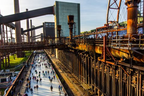 Das große Wasserbecken am ehemaligen Druckmaschinengleis [C74] auf der Kokerei Zollverein verwandelt sich im Winter in die 150 Meter lange ZOLLVEREIN® Eisbahn, die zum Freizeitvergnügen in faszinierender Atmosphäre einlädt. Allabendlich wird die Fläche mit der Installation „Monochromatic Red and Blue“ (1999) von Jonathan Speirs und Mark Major zu einem beeindruckenden Lichtkunstwerk.

Areal C [Kokerei], Druckmaschinengleis [C74], Kokereiallee, 45141 Essen

Die Kokerei Zollverein wurde von 1957 bis 1961 nach Plänen des Architekten Fritz Schupp gebaut, nach Erweiterungsarbeiten war sie ab 1973 die größte Zentralkokerei Europas. Täglich waren bis zu 1.000 Koker rund um die Uhr im Einsatz, bis zu 8.600 Tonnen Koks wurden pro Tag produziert. 1993 wurde die Kokerei stillgelegt, im Jahr 2000 in die Denkmalliste der Stadt Essen aufgenommen, seit 2001 gehört sie zum UNESCO-Welterbe. 2010 ist die Kokerei in den Besitz der Stiftung Zollverein übergegangen. Die „schwarze Seite“ der Kokerei, die den Bereich der Koksproduktion bezeichnet, kann bei einer Führung durch den Denkmalpfad ZOLLVEREIN® besichtigt werden.