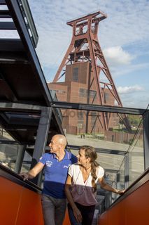 Das 55 Meter hohe Doppelbock-Fördergerüst ist das Wahrzeichen der Zeche Zollverein, der Stadt Essen und der gesamten Region: Die als Doppelstrebengerüst in Vollwandbauweise konstruierte Förderanlage ermöglichte eine doppelte Fördermechanik. Dadurch konnte die doppelte Menge an Förderwagen bzw. Fördergefäßen transportiert werden. Zollverein Schacht XII galt zu Betriebszeiten als die leistungsstärkste Zeche der Welt. 250 Stufen führen auf die oberste Plattform des Gerüstes, deren Seilscheiben sich auch heute noch manchmal drehen: Der Schacht wird von der RAG AG für die zentrale Wasserhaltung genutzt.

Areal A [Schacht XII], Fördergerüst [A1]