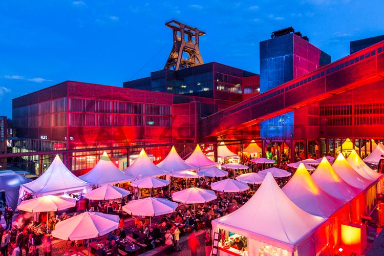 Einmal im Jahr treffen die regionalen Spitzengastronomen zur Gourmet-Meile Metropole Ruhr auf dem UNESCO-Welterbe Zollverein zusammen und verwandeln den Gleisboulevard auf Schacht XII in einen Hot Spot der extravaganten Küche.

Wo heute die Gourmet-Meile und viele andere Veranstaltungen stattfinden, reihten sich zu Betriebszeiten der Zeche Zollverein die Kohlewaggons aneinander.

Bis in die 1960er Jahre sortierten Bergleute in der Lesebandhalle [A12] die großen Gesteinsstücke von Hand aus der Rohkohle heraus, heute ist die Halle 12 Eventlocation und Foyer für Messen, Kongresse und Konzerte.

Die Halle 12 kann für Veranstaltungen angemietet werden. Kontakt: Stiftung Zollverein, Fon +49 201 246 81-355, locations@zollverein.de.

Areal A [Schacht XII], Halle 12 [A12]