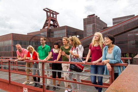 Bis zu 155.000 Besucher nehmen jährlich an einer Führung durch den Denkmalpfad ZOLLVEREIN®  teil, den im Originalzustand erhaltenen Übertageanlagen der Zeche und Kokerei Zollverein.

Die Mannschaftsbrücke war von 1932 bis 1986 der einzige Verbindungsweg für Bergleute zwischen den Zollverein-Schachtanlagen 1/2/8 und XII. 

Bis in die 1960er Jahre sortierten Bergleute in der Lesebandhalle [A12] die großen Gesteinsstücke von Hand aus der Rohkohle heraus, heute ist die Halle 12 Eventlocation und Foyer für Messen, Kongresse und Konzerte.

Die Halle 12 kann für Veranstaltungen angemietet werden. Kontakt: Stiftung Zollverein, Fon +49 201 246 81-355, locations@zollverein.de.

Areal A [Schacht XII], Halle 12 [A12]

Das 55 Meter hohe Doppelbock-Fördergerüst [A1] ist das Wahrzeichen des UNESCO-Welterbe Zollverein, der Stadt Essen und des gesamten Ruhrgebiets.

Areal A [Schacht XII], Fördergerüst [A1]