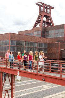 Bis zu 155.000 Besucher nehmen jährlich an einer Führung durch den Denkmalpfad ZOLLVEREIN®  teil, den im Originalzustand erhaltenen Übertageanlagen der Zeche und Kokerei Zollverein.

Die Mannschaftsbrücke war von 1932 bis 1986 der einzige Verbindungsweg für Bergleute zwischen den Zollverein-Schachtanlagen 1/2/8 und XII. 

Bis in die 1960er Jahre sortierten Bergleute in der Lesebandhalle [A12] die großen Gesteinsstücke von Hand aus der Rohkohle heraus, heute ist die Halle 12 Eventlocation und Foyer für Messen, Kongresse und Konzerte.

Die Halle 12 kann für Veranstaltungen angemietet werden. Kontakt: Stiftung Zollverein, Fon +49 201 246 81-355, locations@zollverein.de.

Areal A [Schacht XII], Halle 12 [A12]

Das 55 Meter hohe Doppelbock-Fördergerüst [A1] ist das Wahrzeichen des UNESCO-Welterbe Zollverein, der Stadt Essen und des gesamten Ruhrgebiets.

Areal A [Schacht XII], Fördergerüst [A1]