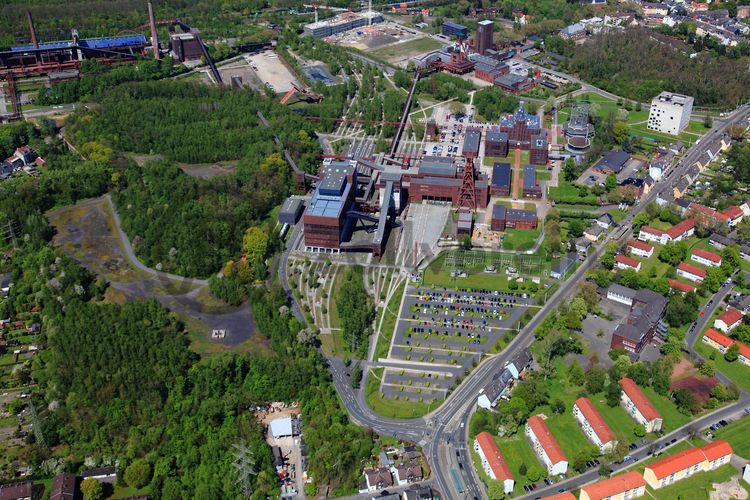 Die Zentralschachtanlage Zollverein XII wurde 1932 in Betrieb genommen und zählte bis zu ihrer Stilllegung 1986 zu den größten und leistungsstärksten Steinkohlenzechen weltweit. Das Meisterwerk der Bergbauarchitektur, geschaffen von den Visionären Fritz Schupp und Martin Kremmer, galt von Beginn an als „schönste Zeche der Welt“. 

Areal A [Schacht XII]