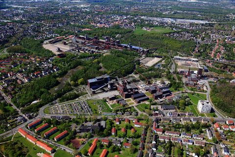 Die Zentralschachtanlage Zollverein XII wurde 1932 in Betrieb genommen und zählte bis zu ihrer Stilllegung 1986 zu den größten und leistungsstärksten Steinkohlenzechen weltweit. Das Meisterwerk der Bergbauarchitektur, geschaffen von den Visionären Fritz Schupp und Martin Kremmer, galt von Beginn an als „schönste Zeche der Welt“. 

Areal A [Schacht XII]

Die Gründungsschachtanlage 1/2/8 war von 1851 bis 1986 in Betrieb und beherbergte u. a. die Sozialräume der Bergleute. Sie wurde im Stil des Historismus errichtet und spiegelt die Hauptepoche des Steinkohlebergbaus im Ruhrgebiet wider. 

Areal B [Schacht 1/2/8]

Die Kokerei Zollverein wurde von 1957 bis 1961 errichtet. Nach einer Erweiterung war die Anlage seit 1973 bis zur Stilllegung 1993 die größte Zentralkokerei Europas.

Areal C [Kokerei]