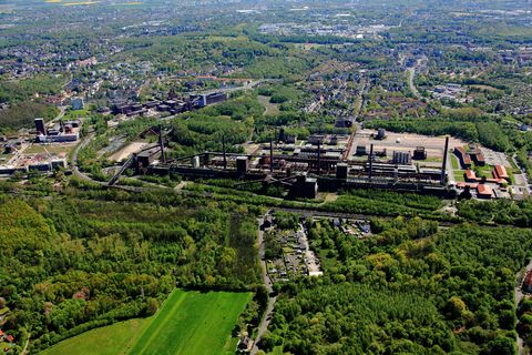 Die Zentralschachtanlage Zollverein XII wurde 1932 in Betrieb genommen und zählte bis zu ihrer Stilllegung 1986 zu den größten und leistungsstärksten Steinkohlenzechen weltweit. Das Meisterwerk der Bergbauarchitektur, geschaffen von den Visionären Fritz Schupp und Martin Kremmer, galt von Beginn an als „schönste Zeche der Welt“. 

Areal A [Schacht XII]

Die Gründungsschachtanlage 1/2/8 war von 1851 bis 1986 in Betrieb und beherbergte u. a. die Sozialräume der Bergleute. Sie wurde im Stil des Historismus errichtet und spiegelt die Hauptepoche des Steinkohlebergbaus im Ruhrgebiet wider. 

Areal B [Schacht 1/2/8]

Die Kokerei Zollverein wurde von 1957 bis 1961 errichtet. Nach einer Erweiterung war die Anlage seit 1973 bis zur Stilllegung 1993 die größte Zentralkokerei Europas.

Areal C [Kokerei]