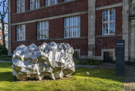 Die Sonne bringt den 590 Kilo schweren „Asteroid PF751ZH“ vor dem Verwaltungsgebäude der Stiftung Zollverein zum Glänzen. Seit 2019 liegt dort die zwei Meter hohe und drei Meter breite Skulptur des Stahlbildhauers HEX. Die Skulptur gehört zu einer Reihe von Asteroid-Skulpturen des Künstlers und entstand 2017.