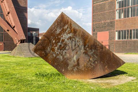 Tonnenschwer und unscheinbar ruht Alf Lechners Skulptur „Konstellation D4“ auf der Wiese vor der Halle 4 in unmittelbarer Nähe des berühmten Doppelbock-Fördergerüsts. Die Skulptur aus der Werkgruppe „Konstellation D1–D8“ steht in einem Winkel von 45 Grad zum rechteckigen Grundriss der Zechengebäude. Sie durchbricht die beiden Achsen, an denen die Anlagen ausgerichtet sind und lenkt den Blick des Betrachters dadurch fast automatisch in Richtung des Doppelbock-Fördergerüsts.

Das südliche Fördermaschinenhaus beherbergte zu Betriebszeiten der Zeche eine der insgesamt zwei Fördermaschinen der Schachtanlage Zollverein XII. Nach der Dach- und Fachsanierung wird es für eine Gastronomie mit Veranstaltungsraum umgebaut.
Halle 4 / The Mine, UNESCO-Welterbe Zollverein, Essen